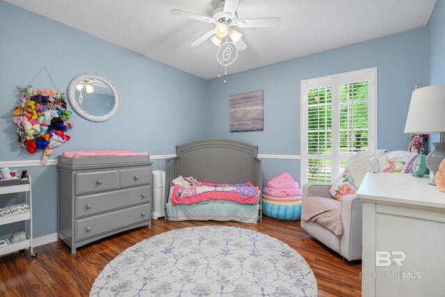 bedroom with a textured ceiling, ceiling fan, wood finished floors, and multiple windows