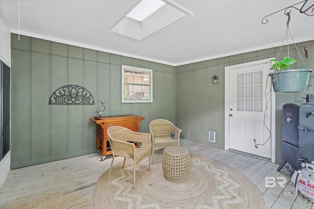 living area with visible vents, wood finished floors, and a skylight