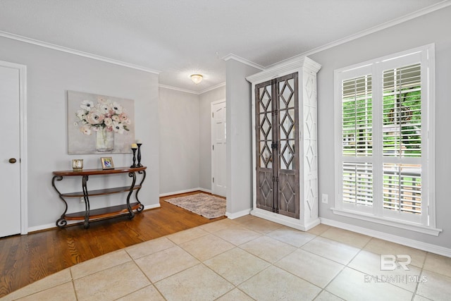 tiled foyer featuring baseboards and ornamental molding