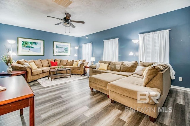 living room with ceiling fan and wood-type flooring