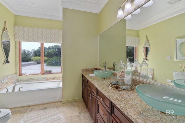 full bath featuring toilet, crown molding, a garden tub, and a sink