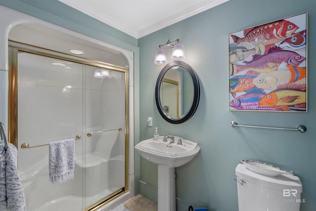 bathroom featuring a sink, toilet, a stall shower, and ornamental molding