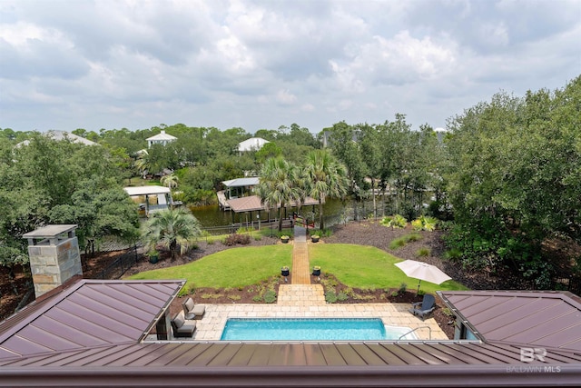 pool with a patio, a yard, and fence