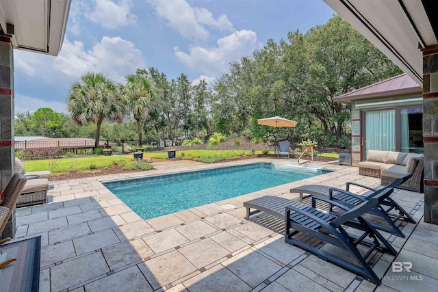 outdoor pool with a patio and an outdoor hangout area