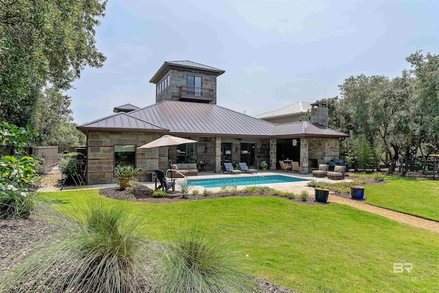 back of property featuring a standing seam roof, a patio area, stone siding, and metal roof