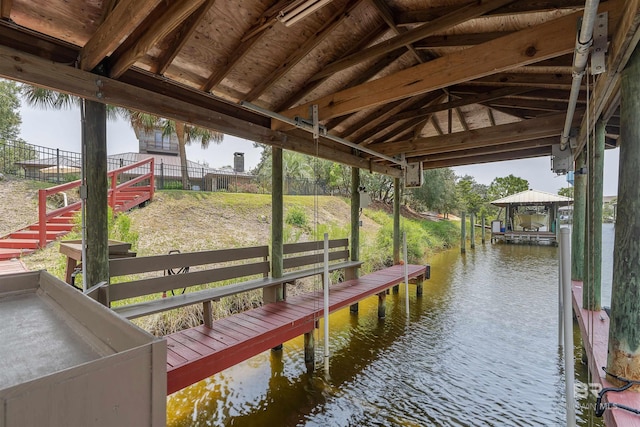 dock area featuring fence and a water view