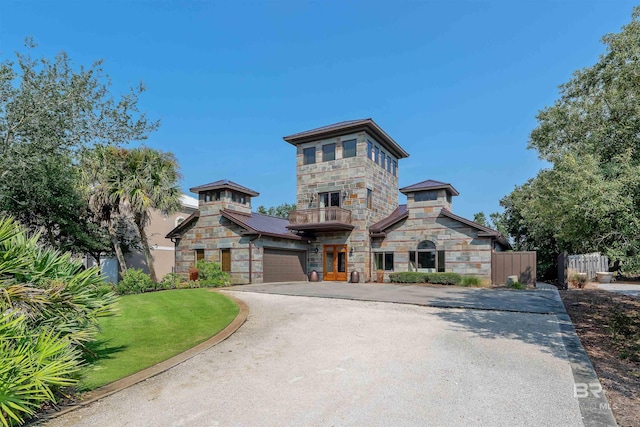 view of front of house featuring fence, stone siding, and driveway