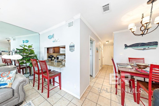 dining room featuring ornamental molding, a chandelier, light tile patterned floors, and baseboards