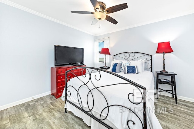 bedroom with crown molding, baseboards, wood finished floors, and ceiling fan