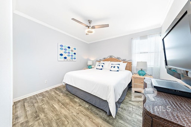 bedroom featuring wood finished floors, crown molding, baseboards, and ceiling fan