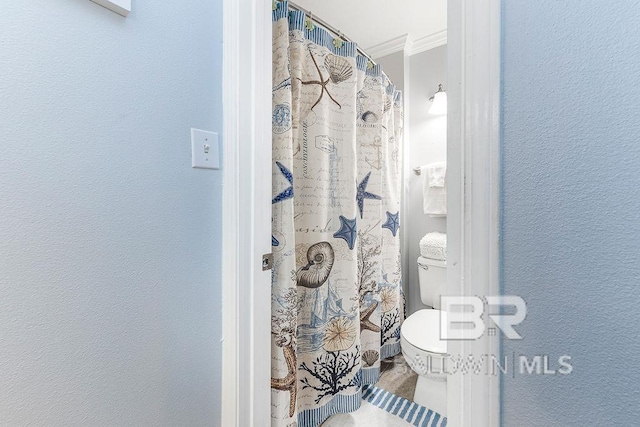 full bathroom with ornamental molding, a textured wall, toilet, and a shower with shower curtain