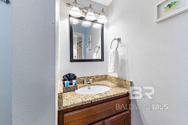 bathroom with vanity and a textured wall