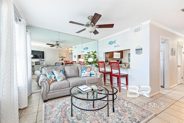 living room with ceiling fan, crown molding, light tile patterned flooring, and baseboards