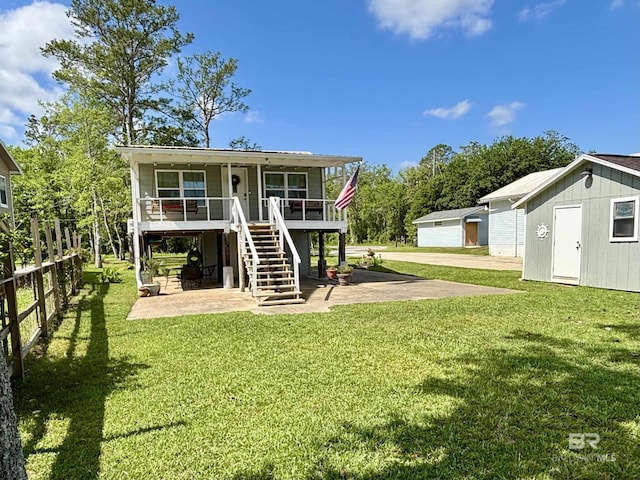 exterior space featuring a yard, an outbuilding, stairs, and a patio