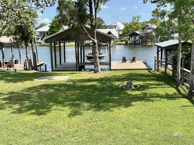 dock area with a water view, boat lift, and a lawn
