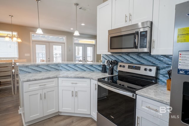 105 Strand Ct, Dauphin Island, AL 36528 - kitchen with visible vents, a peninsula, stainless steel appliances, white cabinets, and french doors
