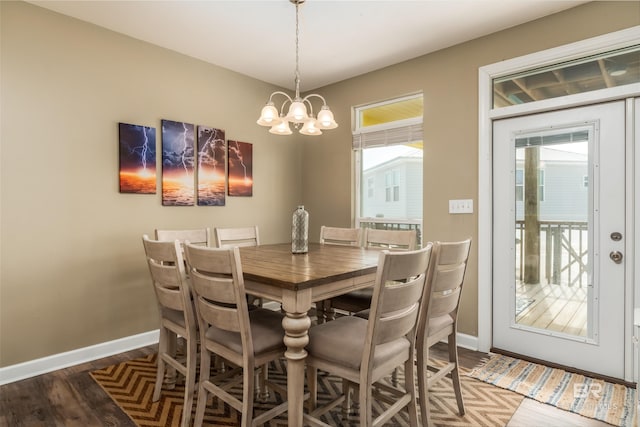 105 Strand Ct, Dauphin Island, AL 36528 - dining area with wood finished floors, a notable chandelier, a healthy amount of sunlight, and baseboards