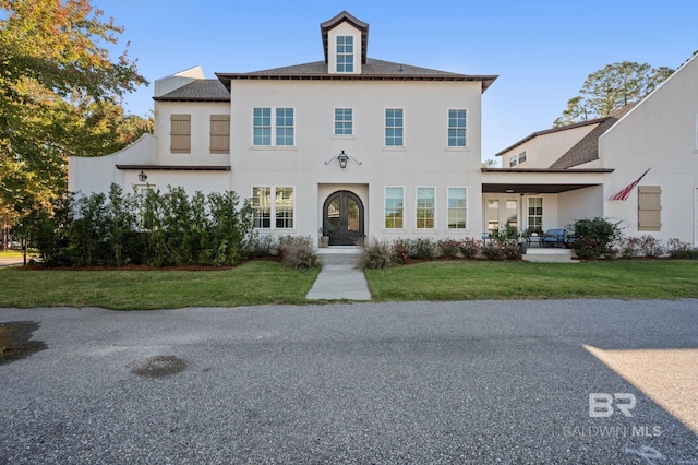 view of front of house featuring french doors and a front lawn