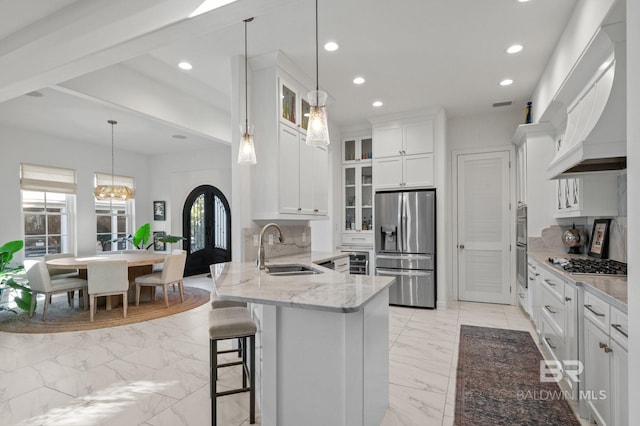 kitchen with white cabinets, sink, stainless steel appliances, and tasteful backsplash