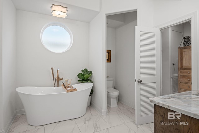 bathroom featuring a tub to relax in, vanity, and toilet