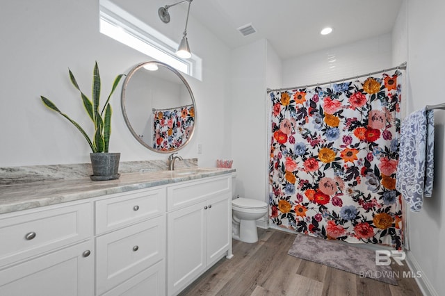 bathroom with a shower with shower curtain, vanity, hardwood / wood-style flooring, and toilet