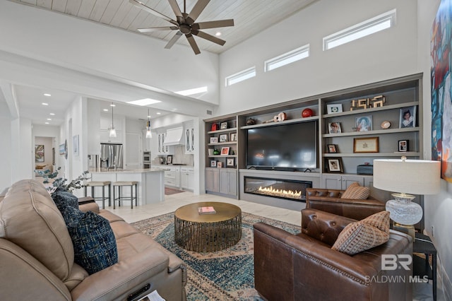 tiled living room with ceiling fan, wood ceiling, and a high ceiling