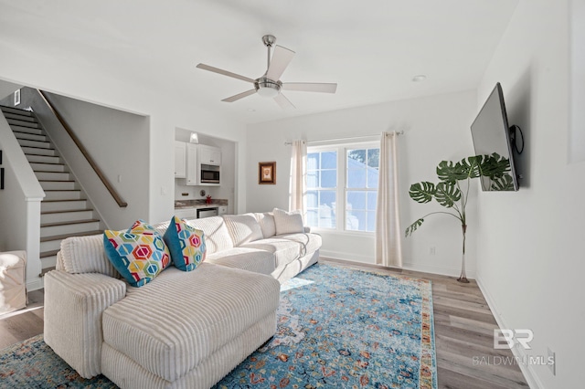 living room featuring light hardwood / wood-style flooring and ceiling fan