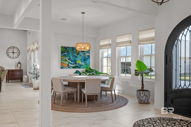 dining area with beam ceiling and an inviting chandelier