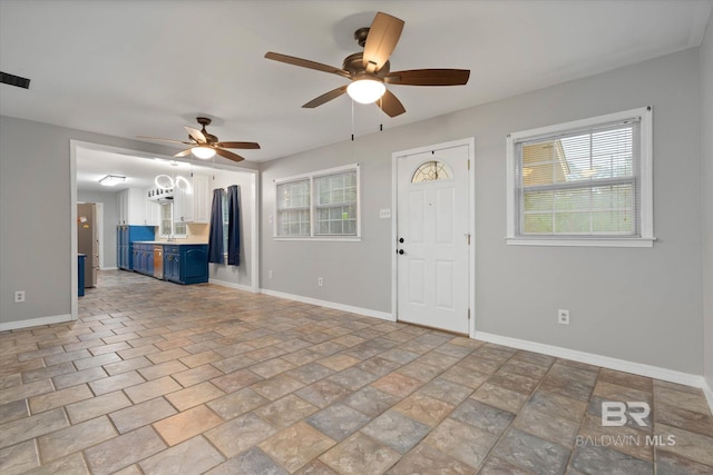 409 E Byron Ave, Mobile, AL 36609 - unfurnished living room featuring ceiling fan, healthy amount of natural light, and light stone finish floors