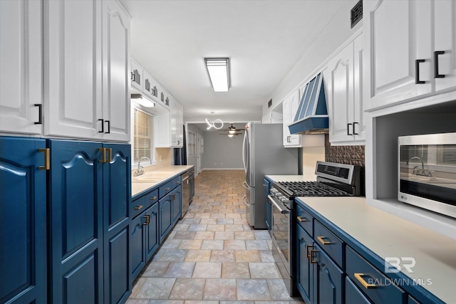409 E Byron Ave, Mobile, AL 36609 - kitchen featuring appliances with stainless steel finishes, custom range hood, blue cabinetry, and white cabinetry