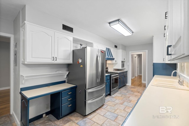 409 E Byron Ave, Mobile, AL 36609 - kitchen with appliances with stainless steel finishes, white cabinetry, stone finish floors, and blue cabinets
