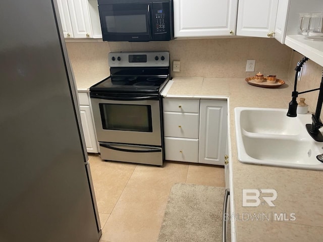 kitchen with appliances with stainless steel finishes, light countertops, white cabinetry, and a sink