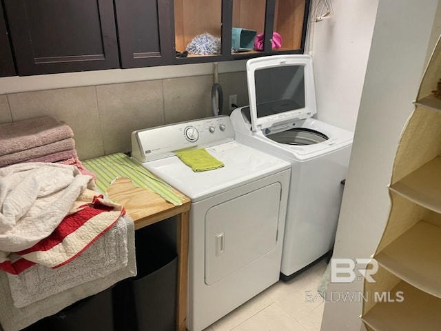 washroom with light tile patterned floors, laundry area, and washer and clothes dryer