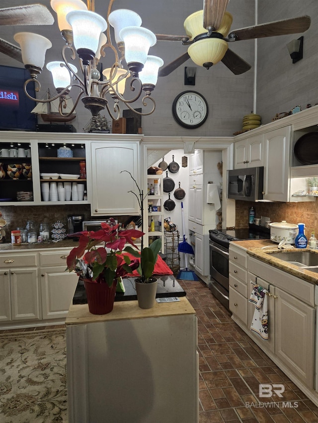 kitchen with open shelves, stainless steel appliances, decorative backsplash, white cabinets, and a sink