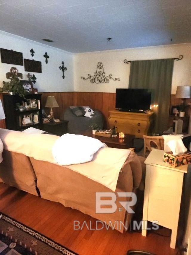 bedroom featuring wood walls and wainscoting