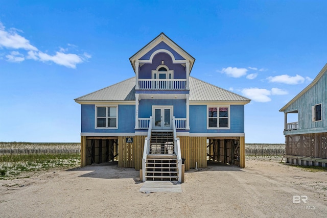 307 Audubon Pl, Dauphin Island, AL 36528 - raised beach house featuring french doors, stairs, metal roof, driveway, and a carport