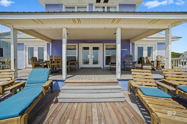 307 Audubon Pl, Dauphin Island, AL 36528 - rear view of house with a wooden deck, french doors, and outdoor dining space
