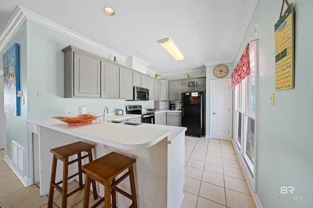 307 Audubon Pl, Dauphin Island, AL 36528 - kitchen featuring crown molding, light tile patterned flooring, appliances with stainless steel finishes, and a peninsula