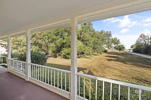 wooden terrace featuring a lawn