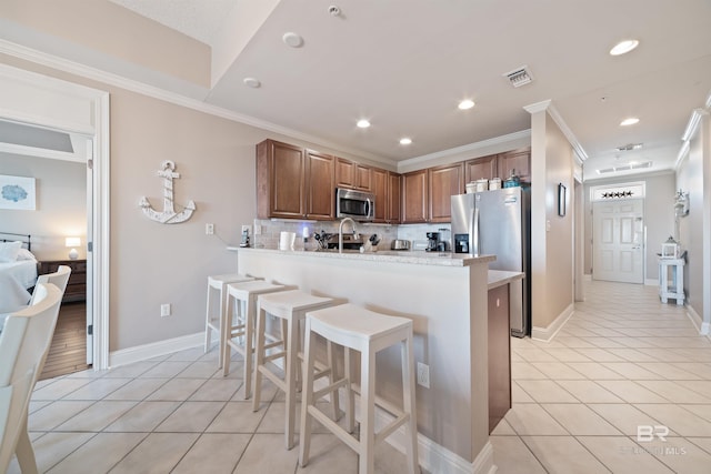 kitchen featuring stainless steel appliances, kitchen peninsula, light tile patterned floors, a breakfast bar, and backsplash