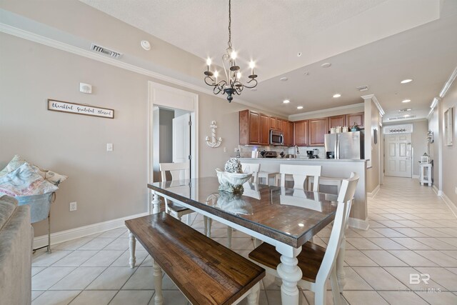 dining area with a notable chandelier, ornamental molding, and light tile patterned floors