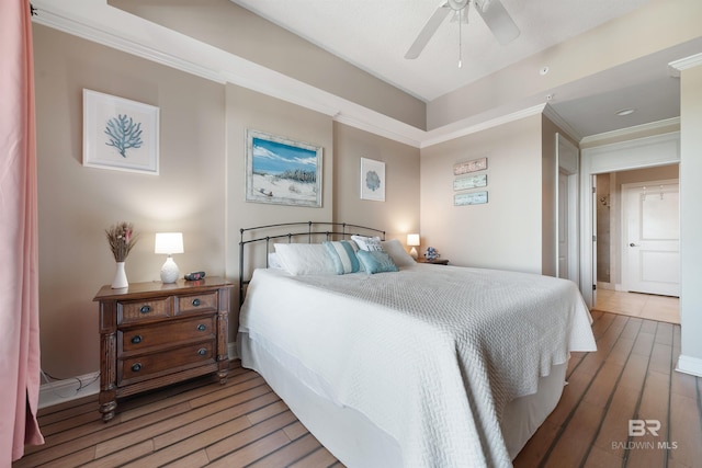 bedroom featuring hardwood / wood-style floors, ceiling fan, and crown molding