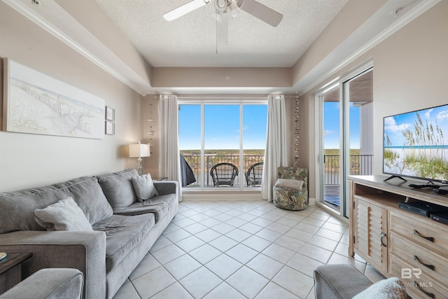 tiled living room with a textured ceiling, ceiling fan, and a healthy amount of sunlight