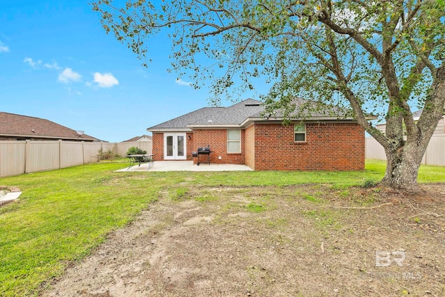 rear view of house with a patio and a yard