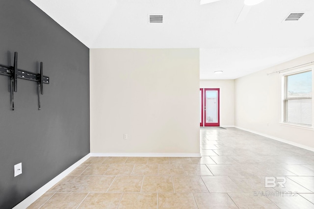 tiled spare room featuring ceiling fan