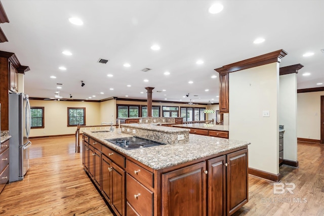 kitchen featuring crown molding, ceiling fan, light hardwood / wood-style flooring, and a large island