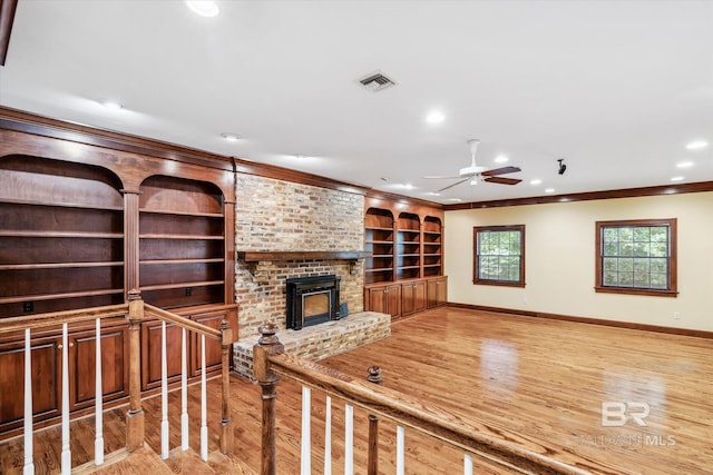 living room with light wood-type flooring, ceiling fan, and crown molding