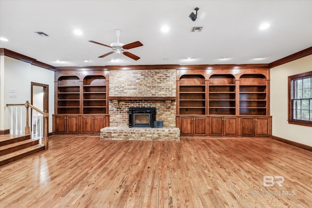 unfurnished living room with light wood-type flooring, a brick fireplace, ceiling fan, and ornamental molding