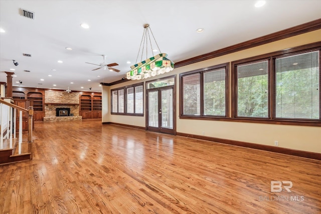 unfurnished living room with ceiling fan, a fireplace, light hardwood / wood-style floors, and ornamental molding