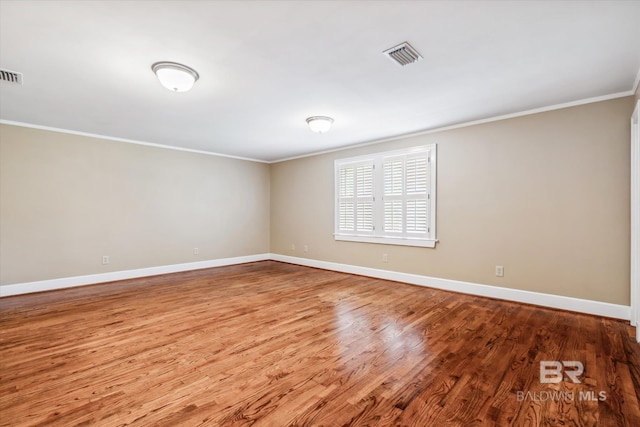 unfurnished room with hardwood / wood-style floors and ornamental molding